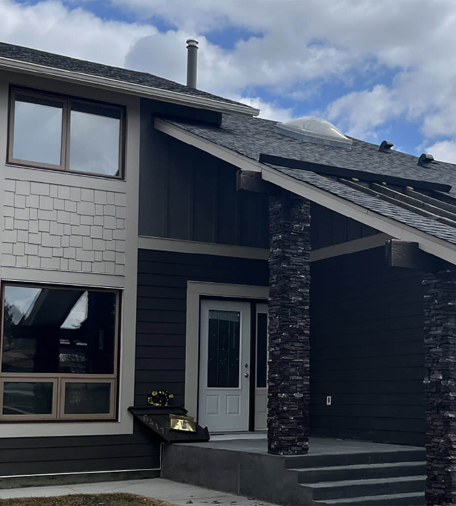 Dark gray house with James Hardie siding and stone columns