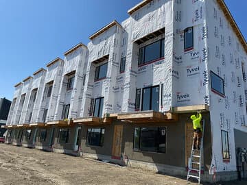 Multi-unit building under construction with exterior wrap installed