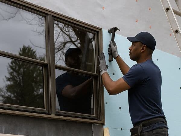 Contractor installing an exterior window during home construction